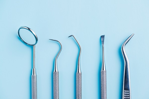 Dental Tool And Artificial Jaw Model For Dental Treatment On A Blue Background.